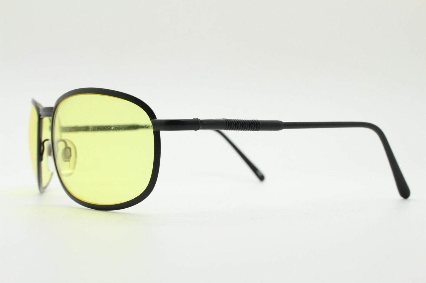 90s vintage oval bug eye sunglasses. Matt black metal frame with blazing yellow lenses and ingenious temple springs. 2000s. NOS