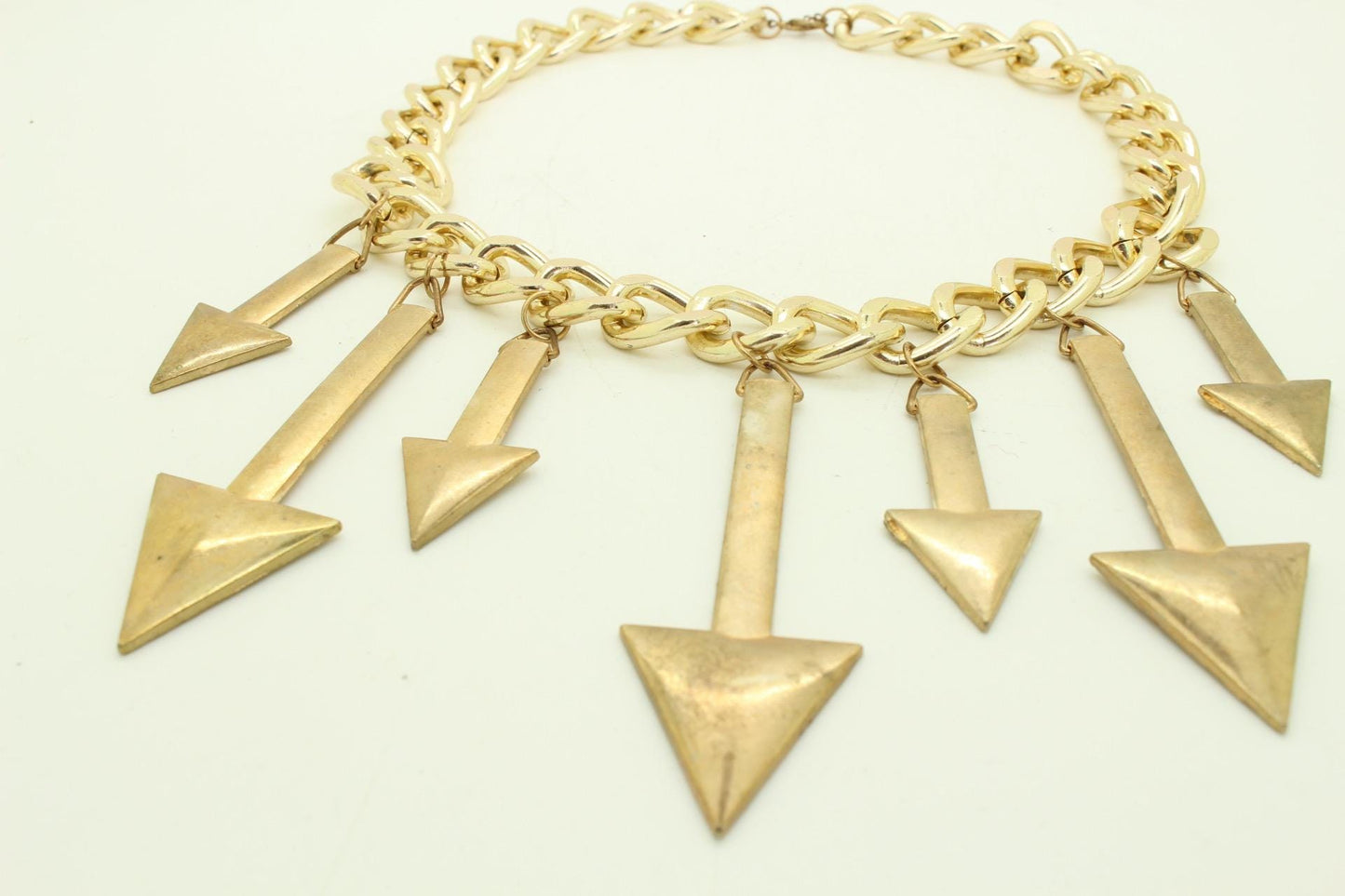 80s vintage massive arrows on a chain necklace. Bombastic golden shiny metal arrows in different sizes on a chunky fat chain. Hip Hop