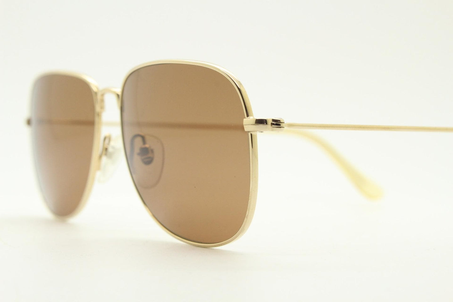 Helmut Lang rectangular 90s vintage sunglasses made in Japan. Minimal gold chrome frame with warm brown lenses. Luxury modified aviator