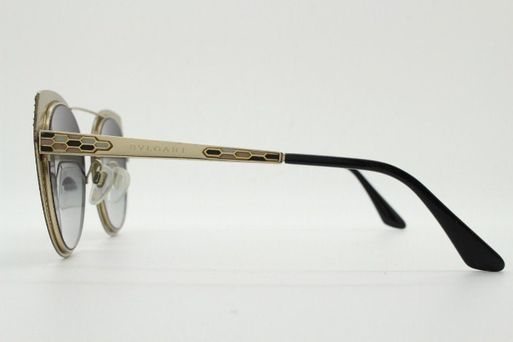 Bulgari round cropped cat eye sunglasses made in Italy. Womens black and gold frame with honeycomb patterns and smoky graduating lenses
