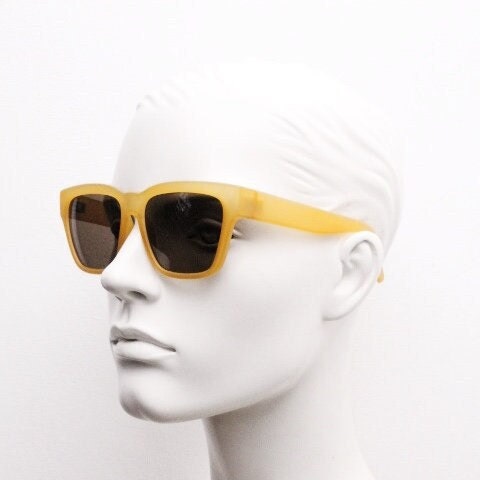 IDC lunettes modified wayfarer design sunglasses made in France. Transparent frosted yellow acetate chunky frame with contrasting lenses