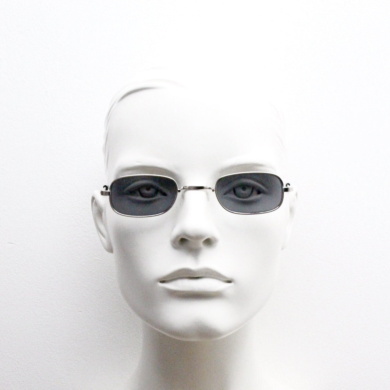 80s vintage rectangular low profile metal sunglasses. Minimal 60s mens mod design in silver chrome frame with grey lenses. NOS