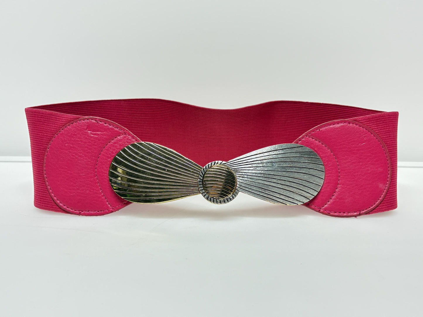 80s vintage womens tall pink elastic belt. Large winged silver and gold buckle. Flattering cinch effect. Adjustable stretchy size range