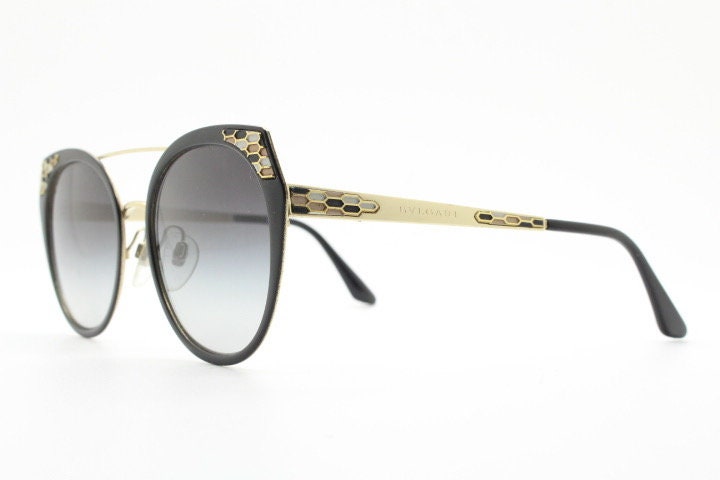 Bulgari round cropped cat eye sunglasses made in Italy. Womens black and gold frame with honeycomb patterns and smoky graduating lenses