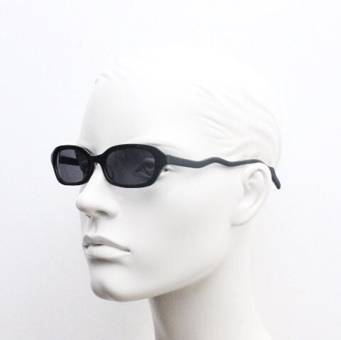 90s vintage rectangular minimal cat eye sunglasses. Small black acetate low profile frame with extraordinary waved arms. Unused NOS