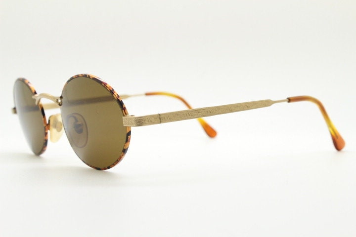 Armandos 90s vintage oval sunglasses made in Italy. Enamelled honey tortoise front with ornate tooled metal arm patterns. NOS