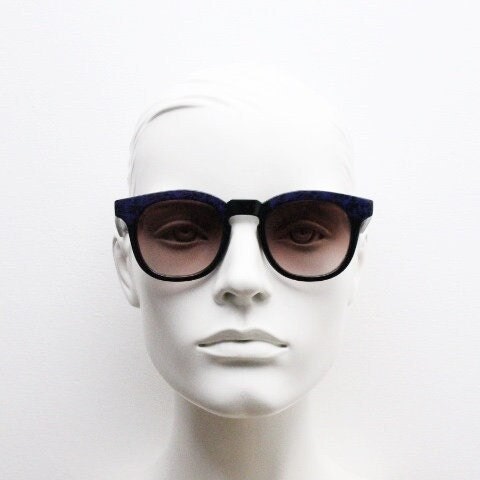 80s vintage rounded wayfarer design sunglasses. Abstract patterned purple brow and arms on a black frame with graduating  lenses. Unused NOS