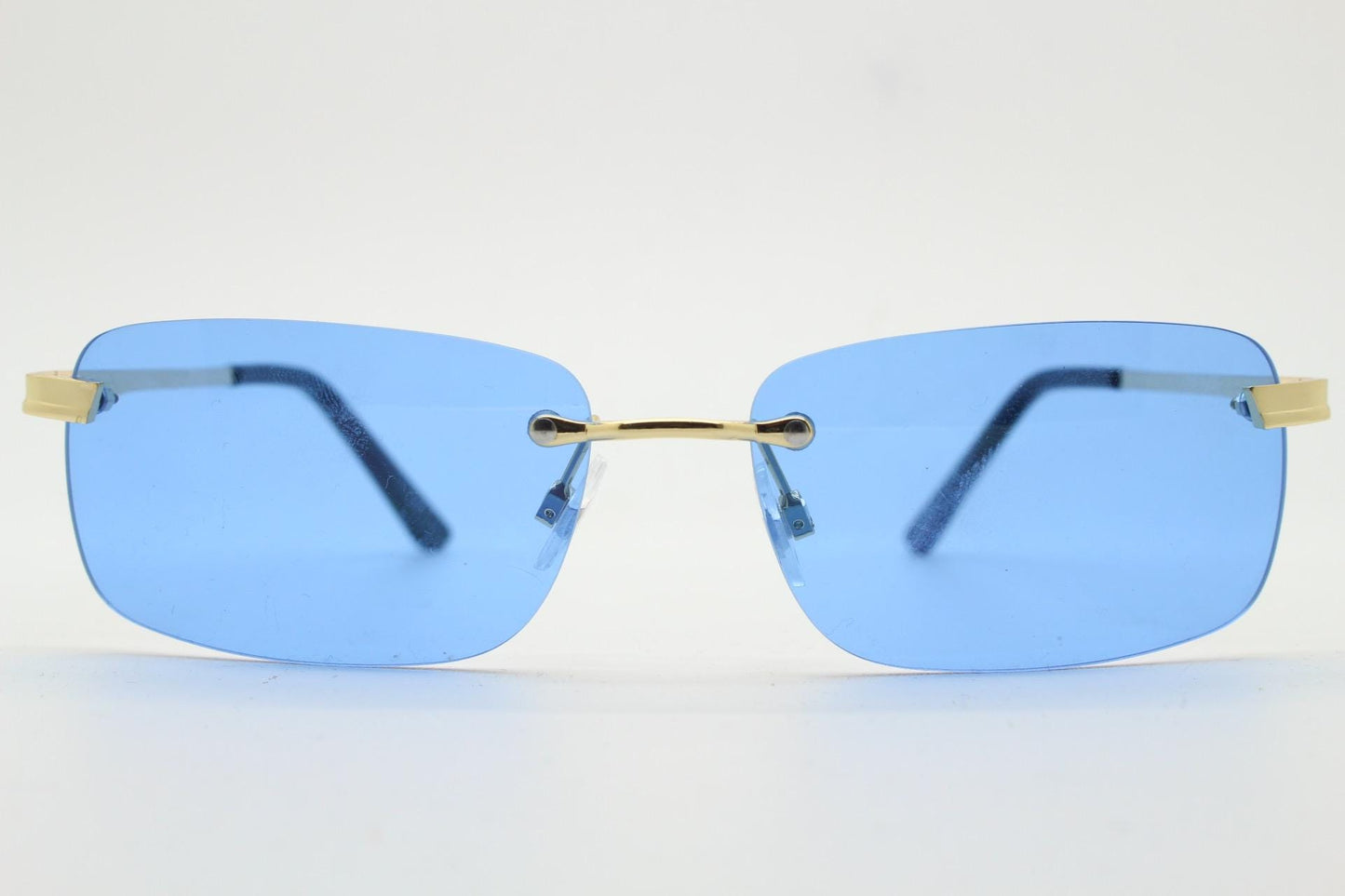 Y2K vintage frameless sky blue sunglasses. Minimalistic rectangular lenses with gold bridge and arms. 2000s club kids. 00's. 90s Rave