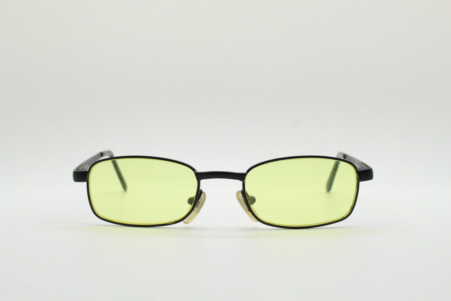 90s vintage small rectangular sunglasses. Minimal plain black matt metal frame with bright yellow lenses. Steampunk. Micro