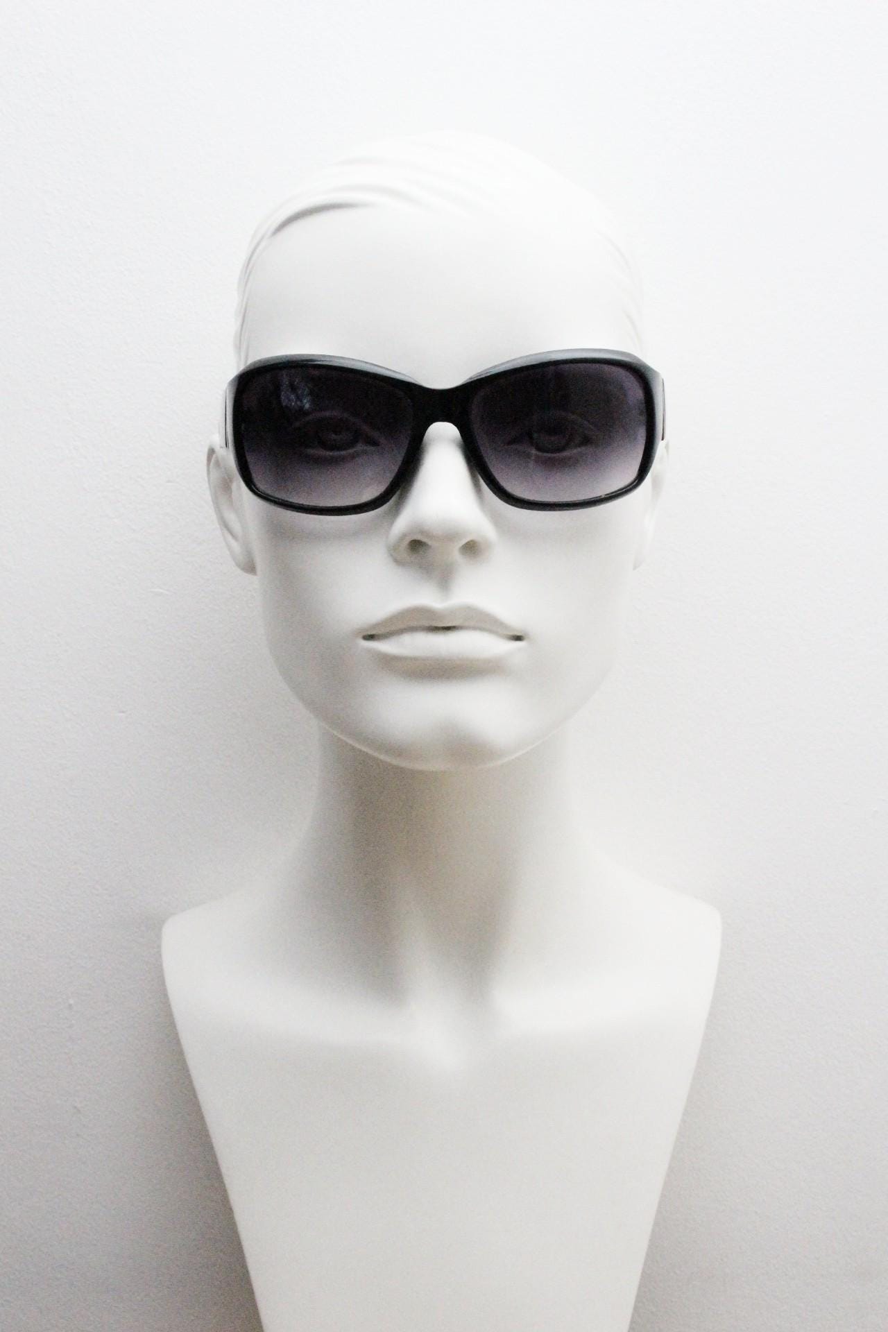 Y2k vintage wrap around sunglasses by Kenneth Cole Reaction. Curved black shield frame with gold trim. 60s bug eye design. 2000's NOS