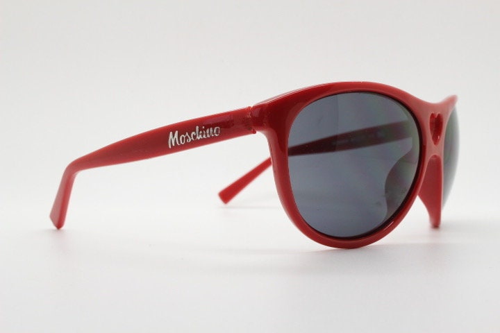 Moschino oversized Y2K vintage sunglasses. Characteristic crimson red acetate frame with cut out heart bridge. 2000s