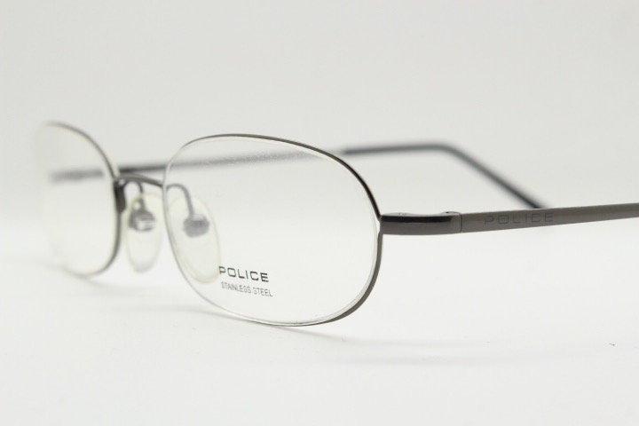 Police 90s vintage oval half rim eye glasses made in Italy. Minimal lightweight optical frame in gunmetal grey. Prescription RX Spectacles