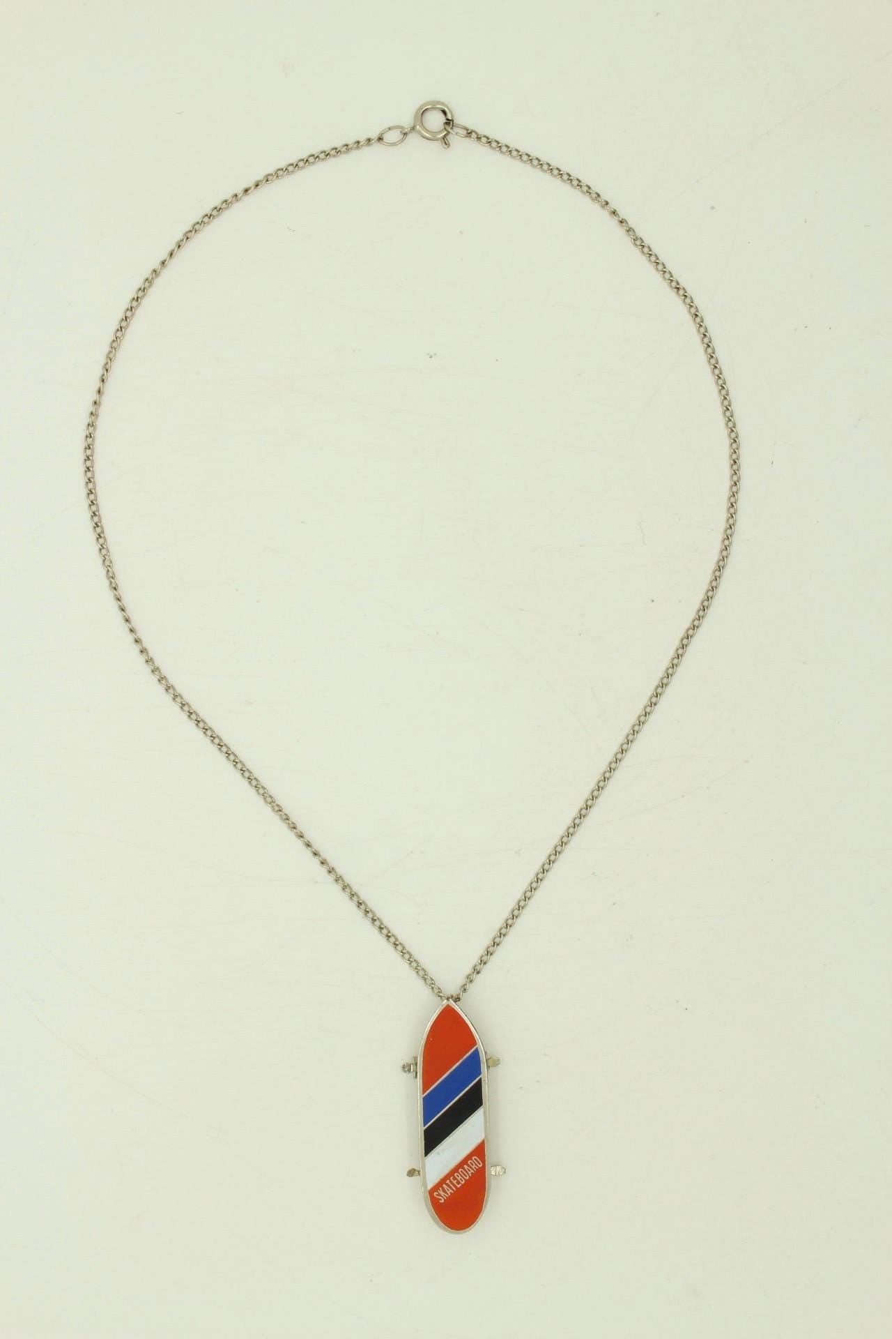 80s vintage skateboard pendant necklace. Metal chrome with enamelled red, blue and white colour stripes. Charming authentic design. NOS