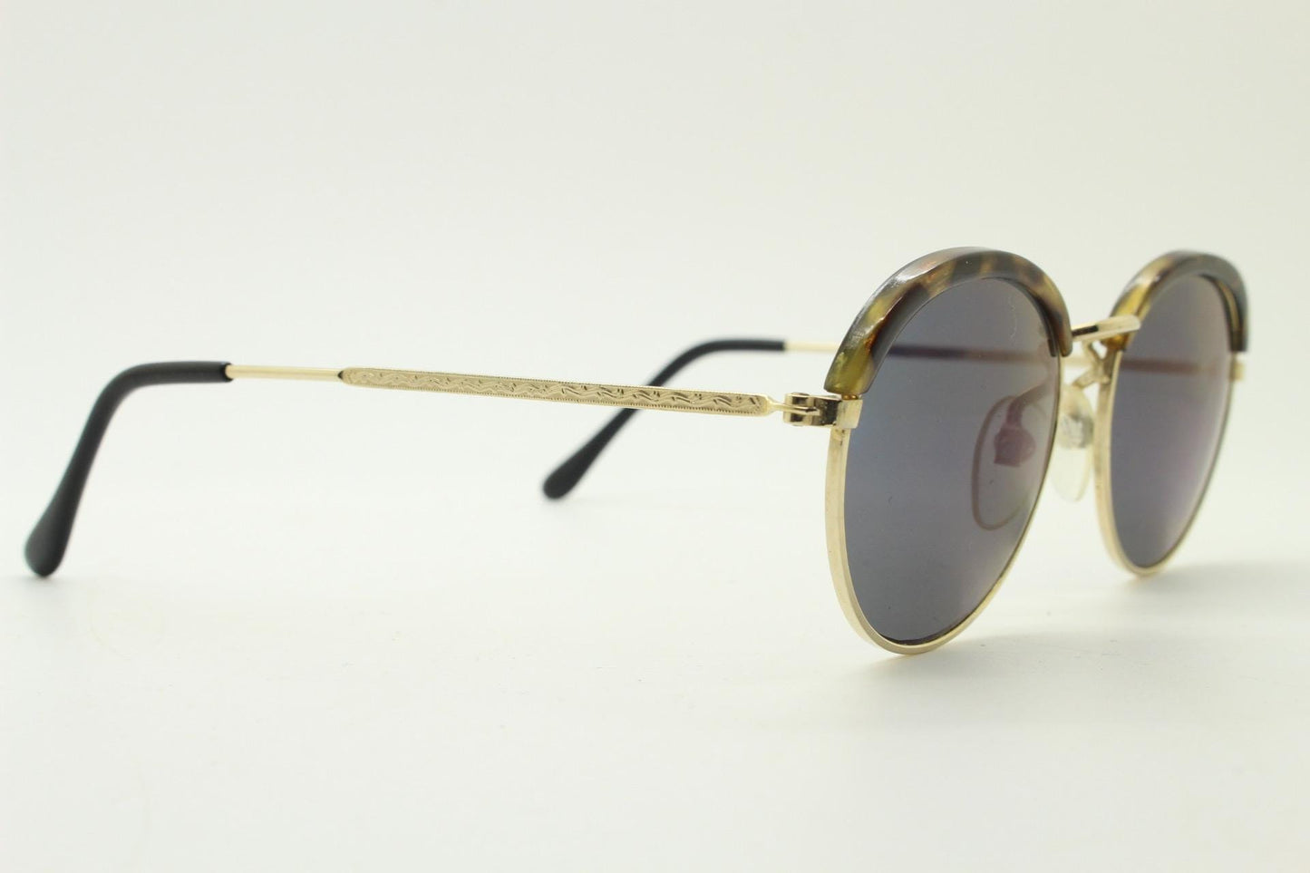 90s round vintage sunglasses. Gold frame with tortoise brows, blue mirror lenses and intricate embossed arm patterns. 1930's style