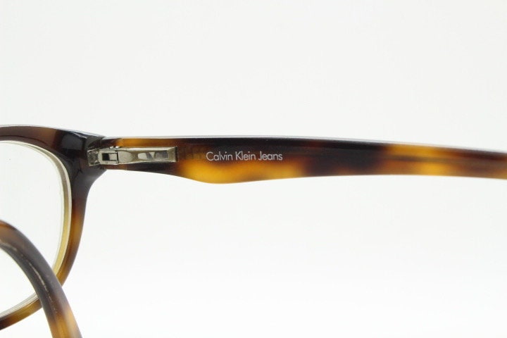 Calvin Klein Jeans modified cat eye glasses model CKJ918. Tortoise gloss low profile acetate optical frames. Prescription eyeglasses. RX