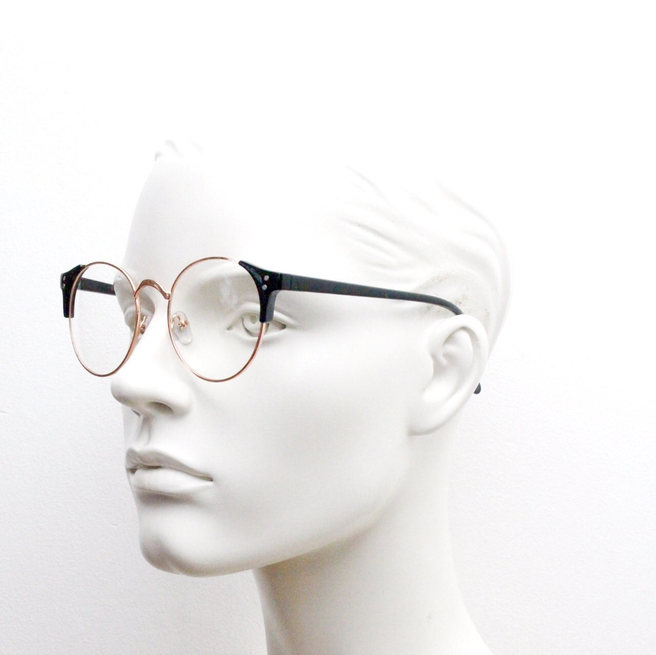 90s vintage modified cat eye glasses. Black arms with a round gold face. 40s, 50s style clear lens eyeglasses. Cateye