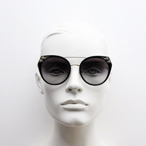 Bulgari round cropped cat eye sunglasses made in Italy. Womens black and gold frame with honeycomb patterns and smoky graduating lenses