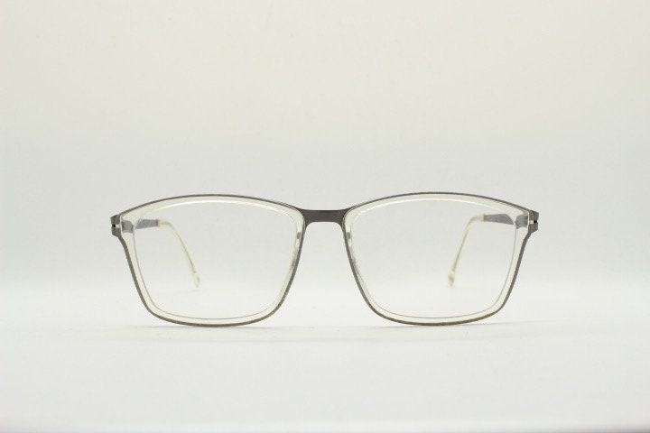 Modo rectangular eye glasses made in Japan. Matt grey titanium optical frame encasing transparent crystal acetate front. Prescription RX