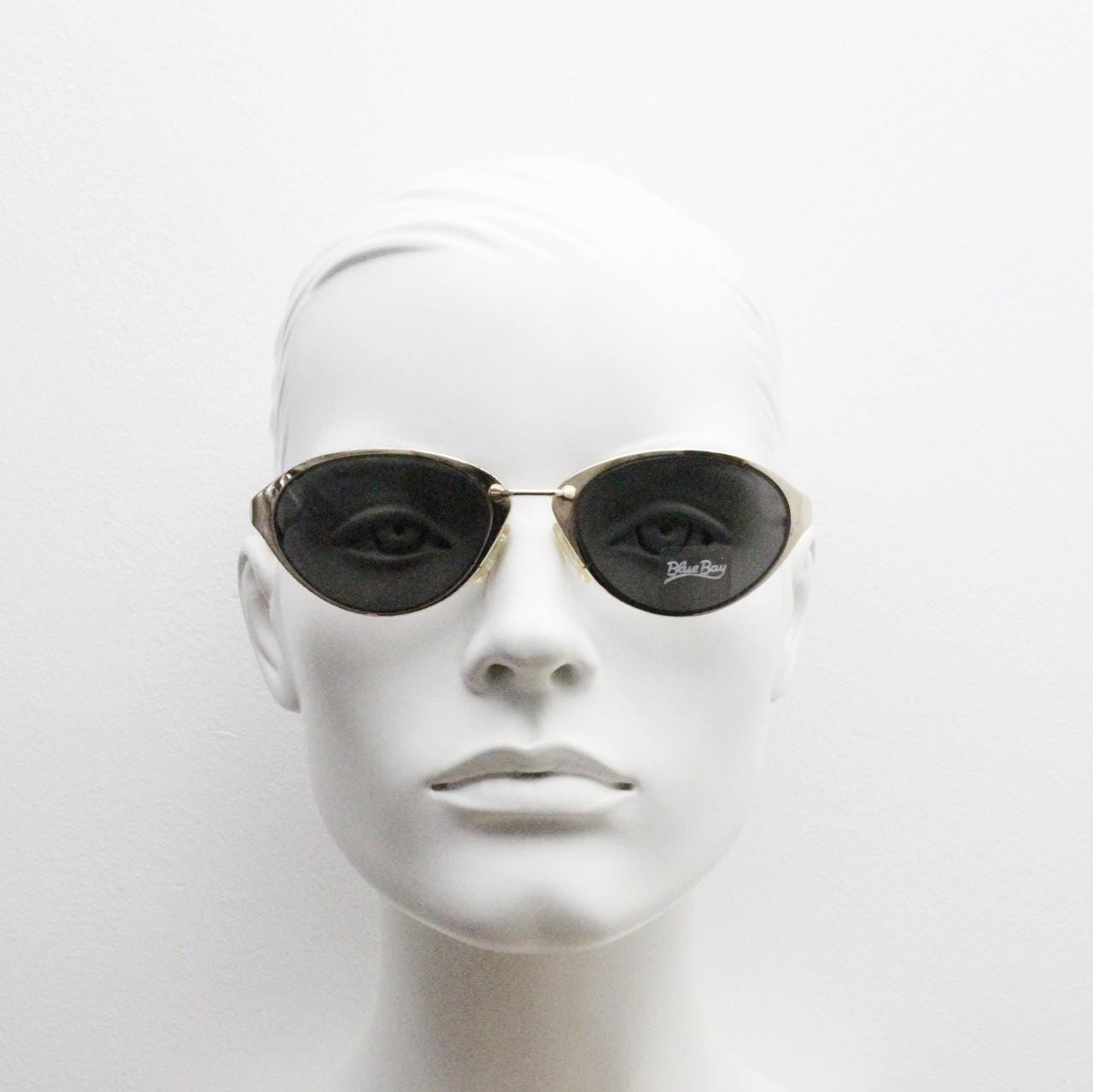 Blue Bay 90s vintage oval cat eye sunglasses made in Italy by Safilo. Dynamic gold chrome finish with contrasting dark lenses. NOS with tag
