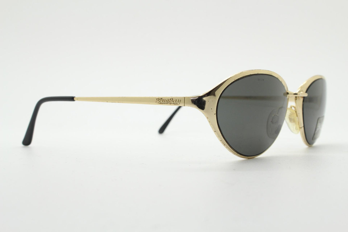 Blue Bay 90s vintage oval cat eye sunglasses made in Italy by Safilo. Dynamic gold chrome finish with contrasting dark lenses. NOS with tag