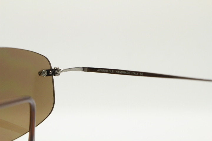 Faconnable 90s vintage sunglasses model 859 hand made in Italy. Minimal frameless design with flexible wire arms and brown chrome trim. NOS
