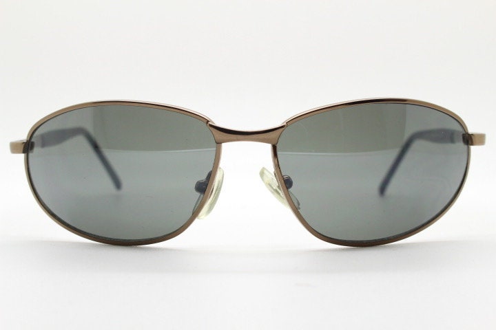 Y2K vintage small bug eye sunglasses. Curved brown chrome metal frame with black arms. Unused 2000s NOS