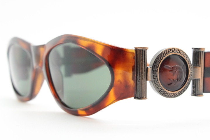 90s vintage oval sunglasses. Low profile transparent tortoise frame with massive bronze metal arm crests BNWT. Unused NOS