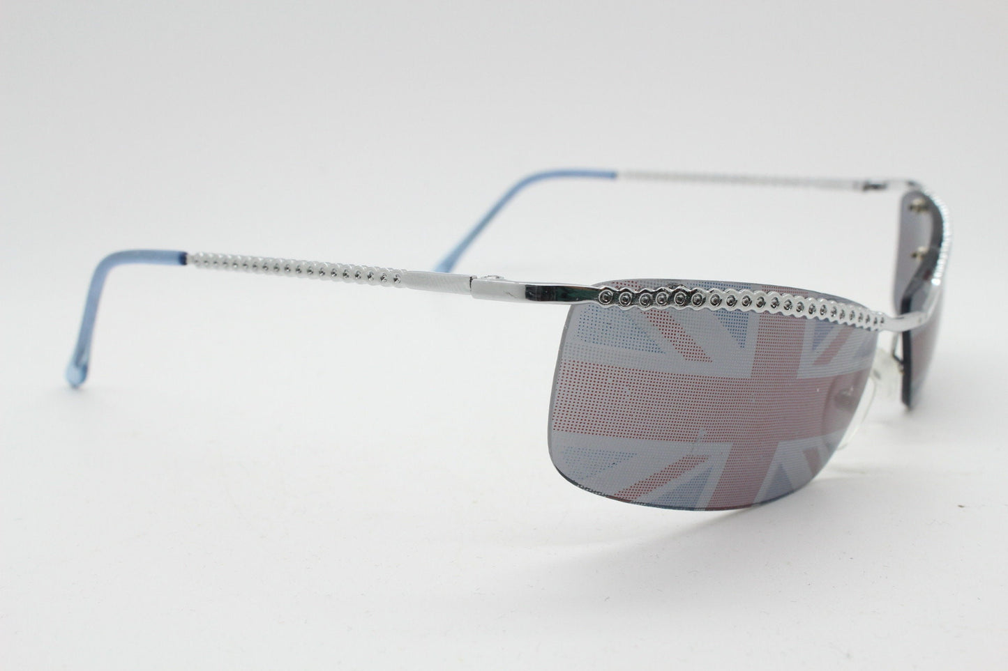 90s vintage half frame Union Jack sunglasses. Curved lens suspended on a sparkling chrome brow. Unused NOS. Brit pop girl power