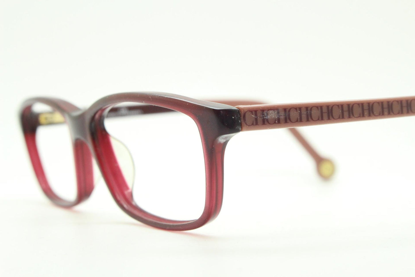 Carolina Herrera rectangular low profile eye glasses. Dark pink acetate optical frames with tasteful arm logo. Prescription RX eyeglasses