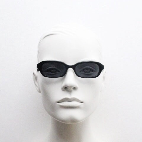 90s vintage rectangular minimal cat eye sunglasses. Small black acetate low profile frame with extraordinary waved arms. Unused NOS