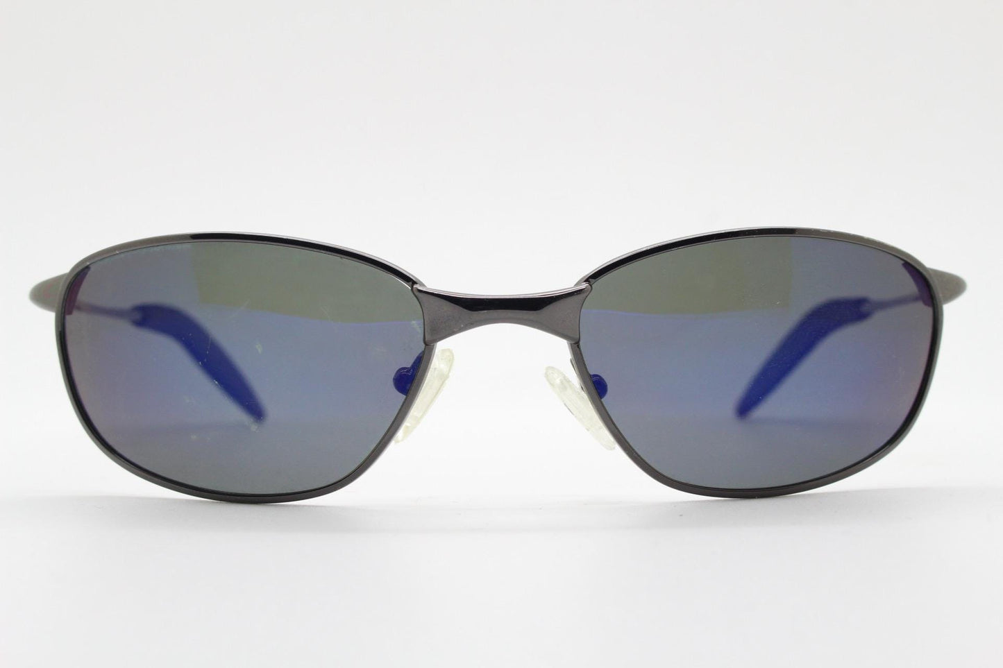 90s vintage curved oval sunglasses. Solid metal low profile frame in grey chrome with slightly mirrored dark lenses. 2000's. Y2K NOS