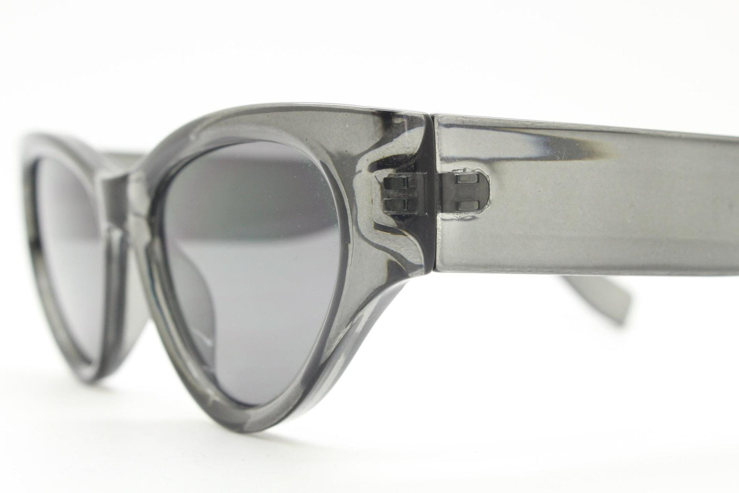 Thick cateye sunglasses with cropped sides and sharp outline. Womens 60s design chunky transparent grey frame and lenses. Y2k vintage