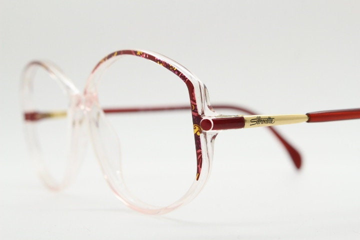 Silhouette 80s vintage hexagon eye glasses made in Austria. Transparent crystal optical frame with abstract red pattern. Prescription RX