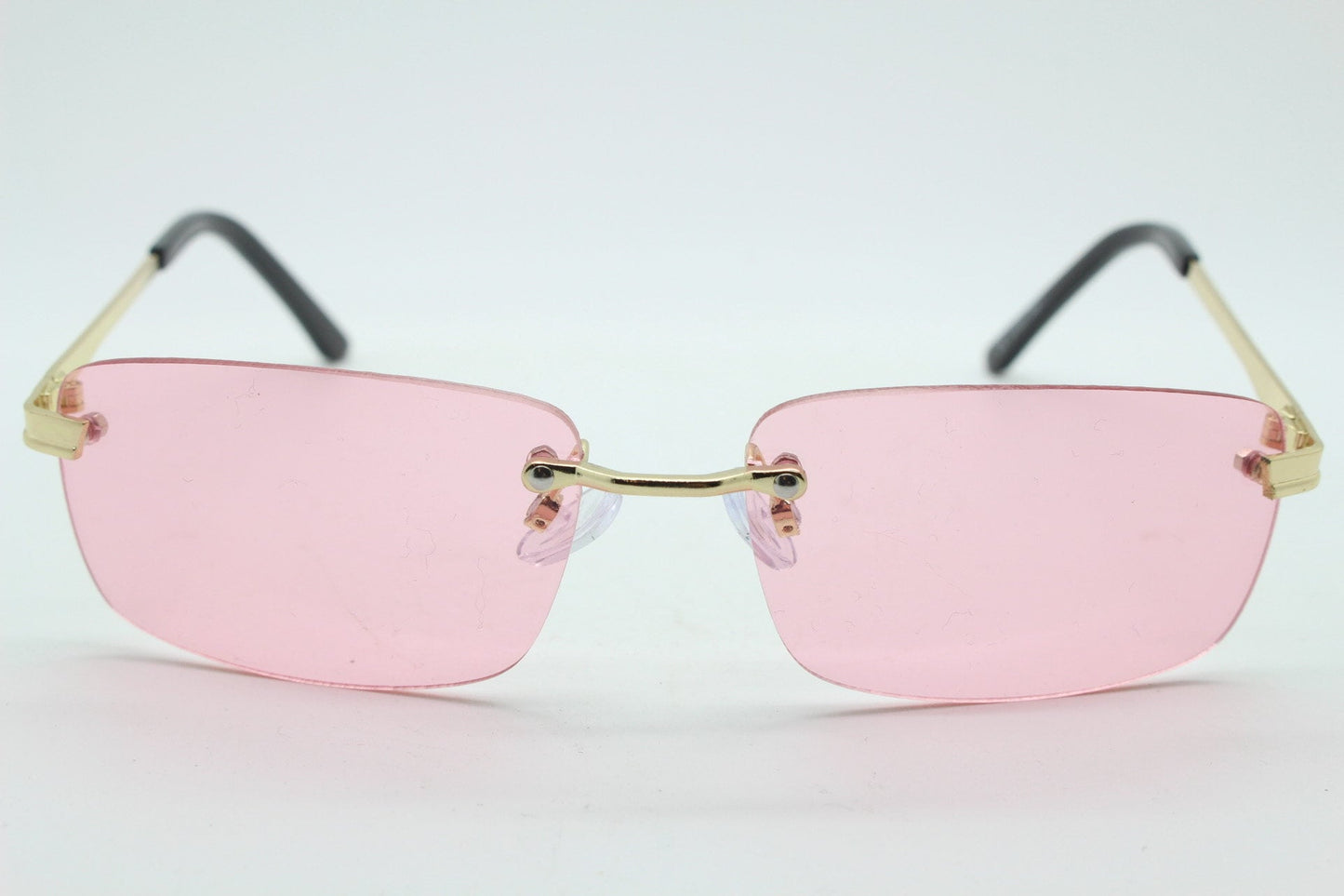 Y2K vintage frameless pink sunglasses. Rectangular lenses with gold bridge and arms. 2000s club kids. 00's. 90s Rave
