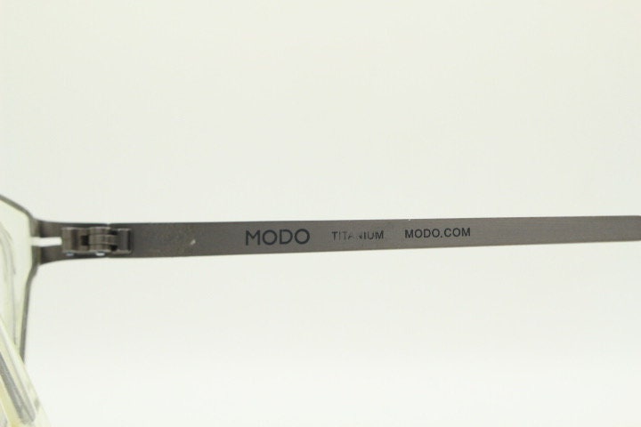 Modo rectangular eye glasses made in Japan. Matt grey titanium optical frame encasing transparent crystal acetate front. Prescription RX