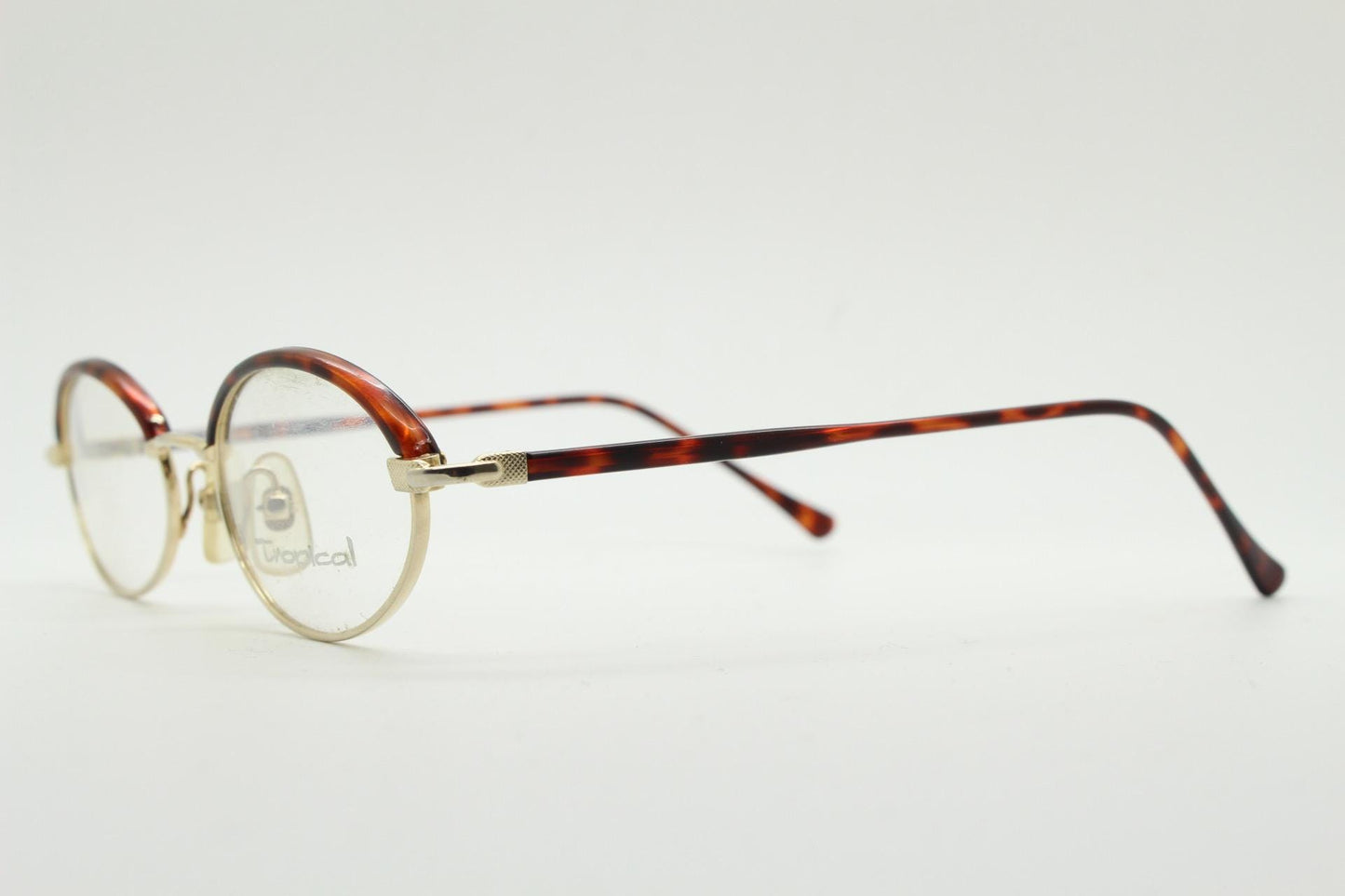 90s vintage small oval eye glasses by Tropical. Minimal gold optical frames with tortoise arms and brows. Prescription RX spectacles. NOS