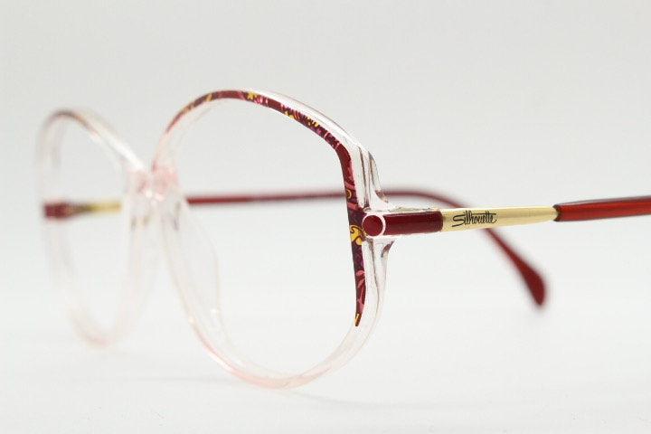 Silhouette 80s vintage hexagon eye glasses made in Austria. Transparent crystal optical frame with abstract red pattern. Prescription RX