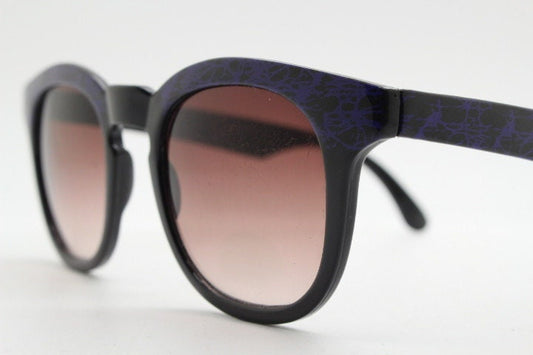 80s vintage rounded wayfarer design sunglasses. Abstract patterned purple brow and arms on a black frame with graduating  lenses. Unused NOS