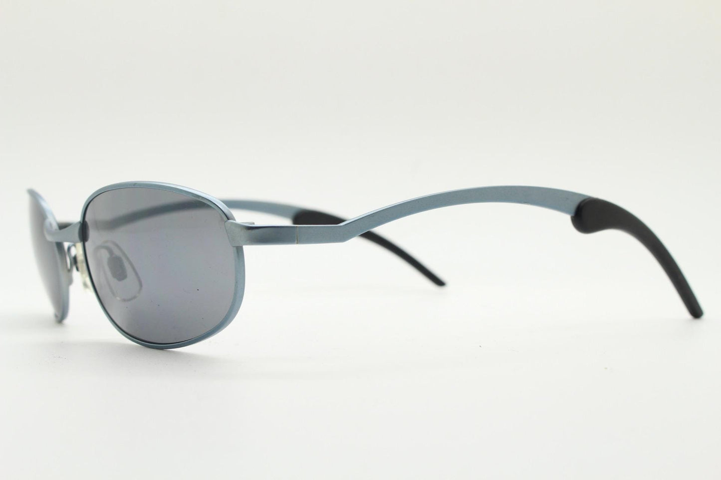 90s vintage oval small bug eye sunglasses. Curved blue satin finish solid metal frame with stylised arched arms and rubber ends. Unused NOS