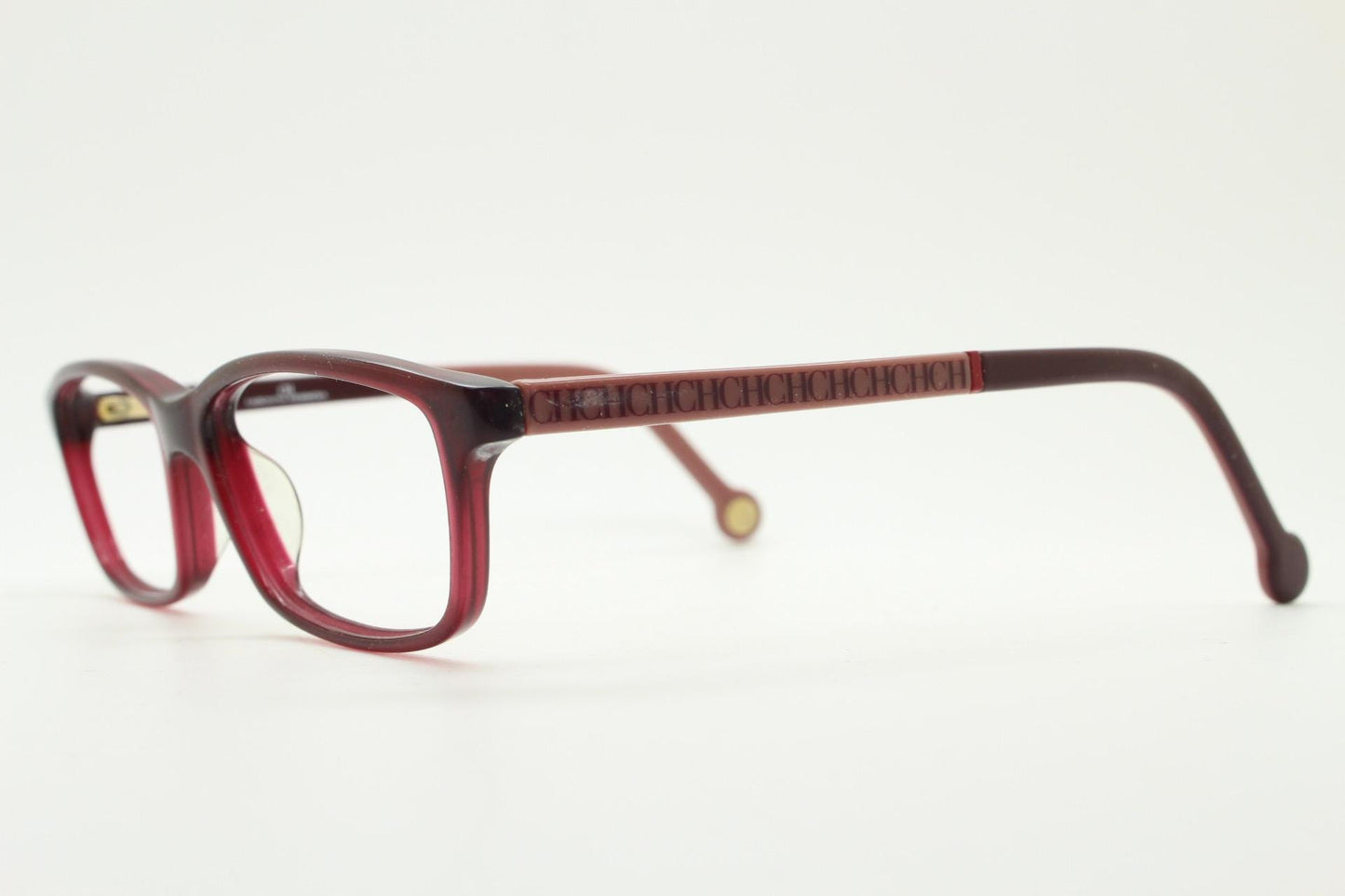 Carolina Herrera rectangular low profile eye glasses. Dark pink acetate optical frames with tasteful arm logo. Prescription RX eyeglasses