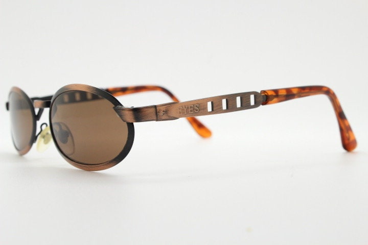 90s vintage oval sunglasses. Handsome metallic brushed copper finish with arm cut outs. Unused NOS