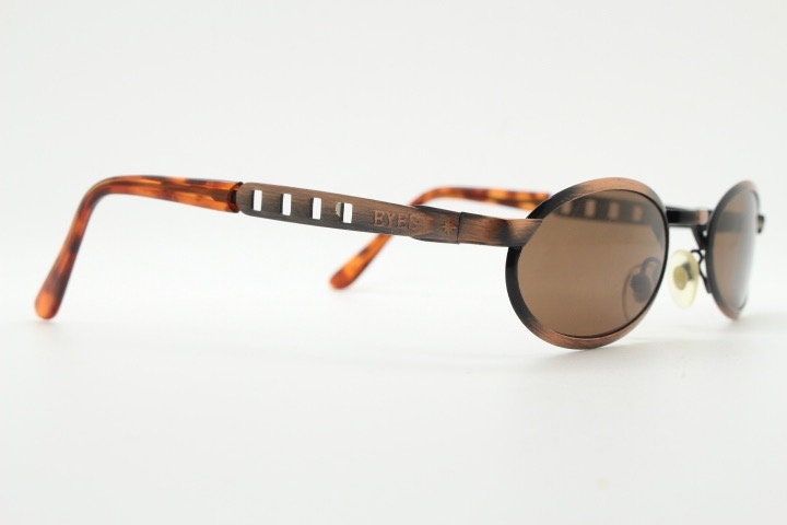 90s vintage oval sunglasses. Handsome metallic brushed copper finish with arm cut outs. Unused NOS