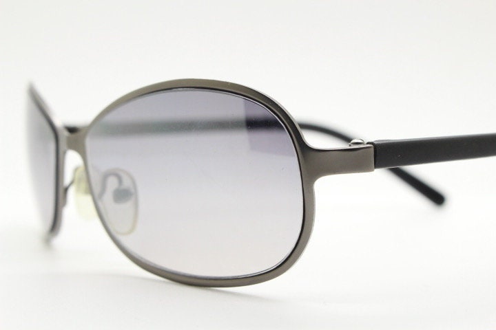 Y2K vintage mini bug eye sunglasses. Curved gunmetal grey flat metal frame with black matt arms and graduating lenses. Unused 2000s NOS