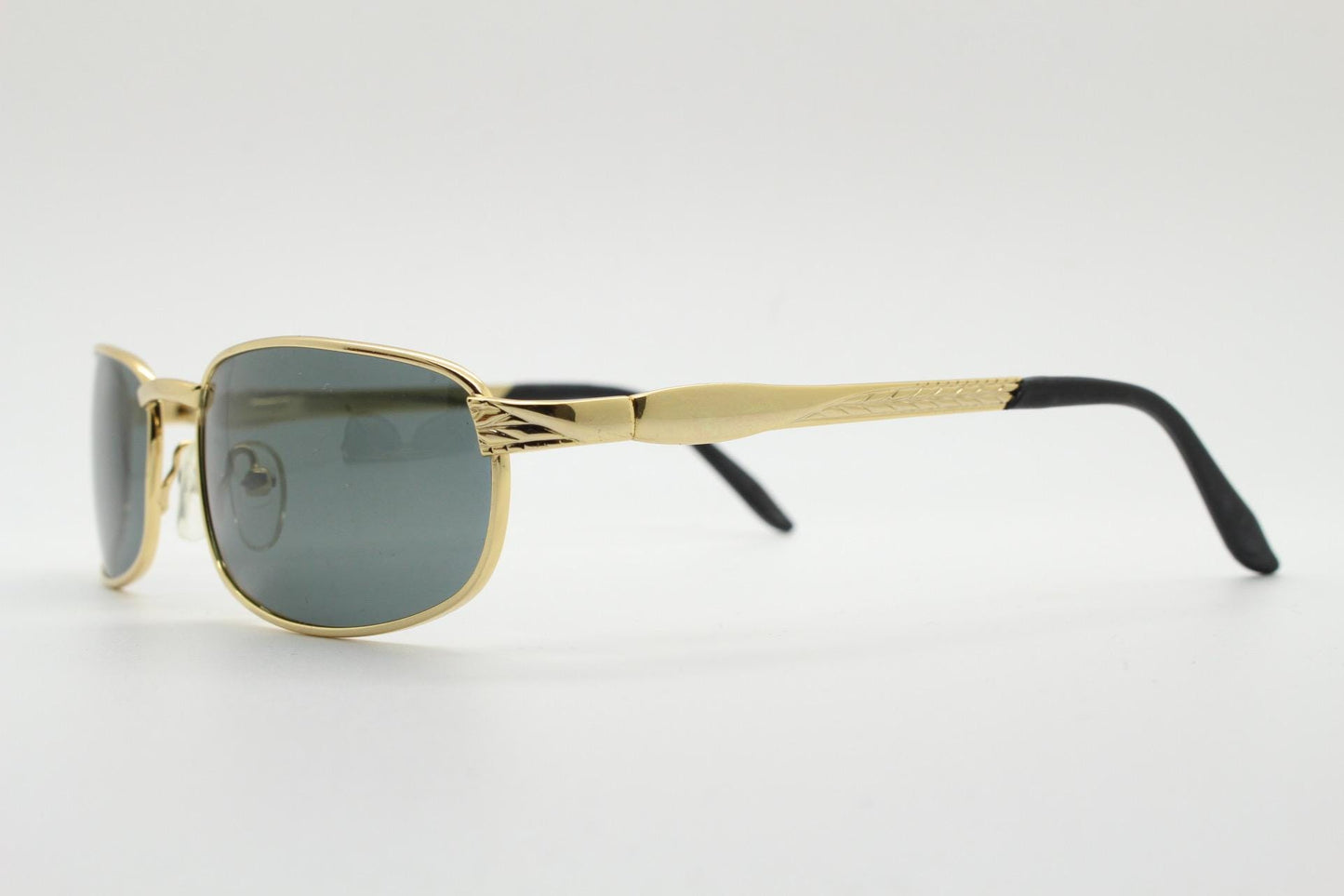 90s vintage low profile gold rectangular sunglasses. Solid metal frame in a shiny chrome finish embossed arm pattern and green lenses. NOS