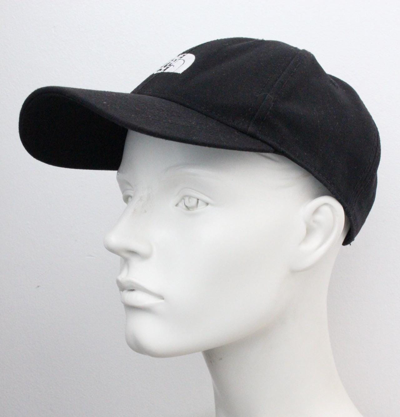 The North Face plain black baseball cap with white spell out logo. Classic trucker style hat with fully adjustable back. One size