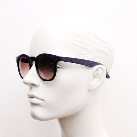 80s vintage rounded wayfarer design sunglasses. Abstract patterned purple brow and arms on a black frame with graduating  lenses. Unused NOS