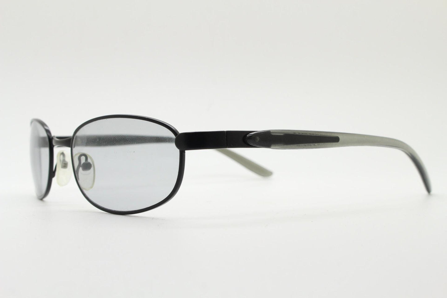 90s vintage oval small bug eye sunglasses. Curved black satin finish metal frame with transparent grey arms and light tone lenses. NOS