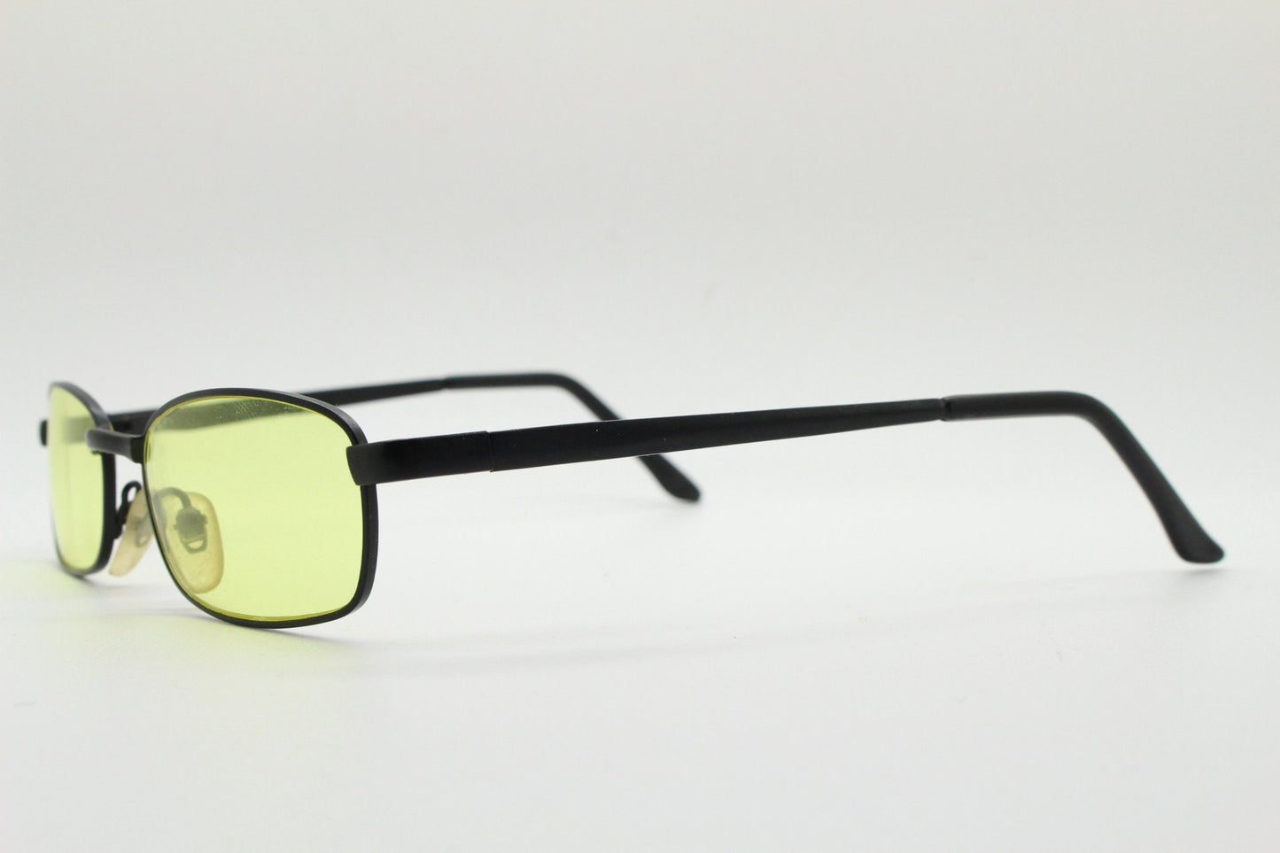 90s vintage small rectangular sunglasses. Minimal plain black matt metal frame with bright yellow lenses. Steampunk. Micro