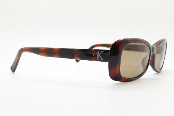 Calvin Klein 90s vintage thick framed rectangular sunglasses. Womens dark tortoise gloss low profile design.