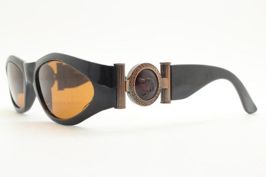 90s vintage oval sunglasses. Low profile black gloss frame with massive bronze metal arm crests and brown lenses. BNWT. Unworn NOS